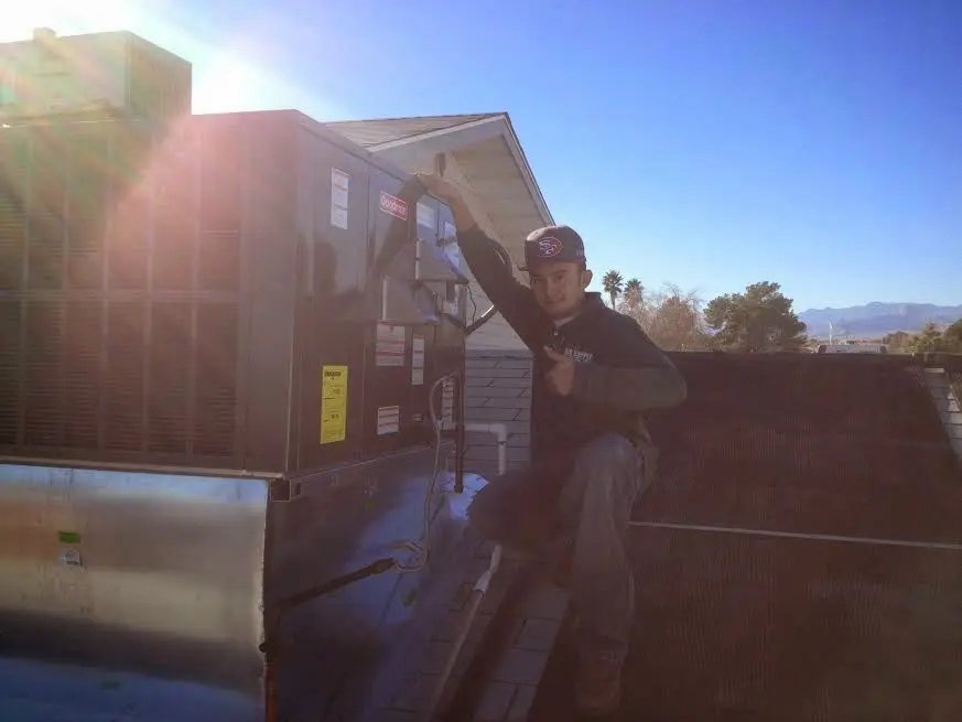 HVAC technician performing Boiler Repair on a rooftop unit in Long Branch